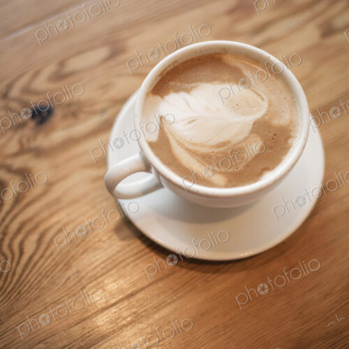 A cup of frothy coffee in a white china cup with a saucer. Cappuchino. A cup of frothy coffee in a white china cup with a saucer. Cappuchino.