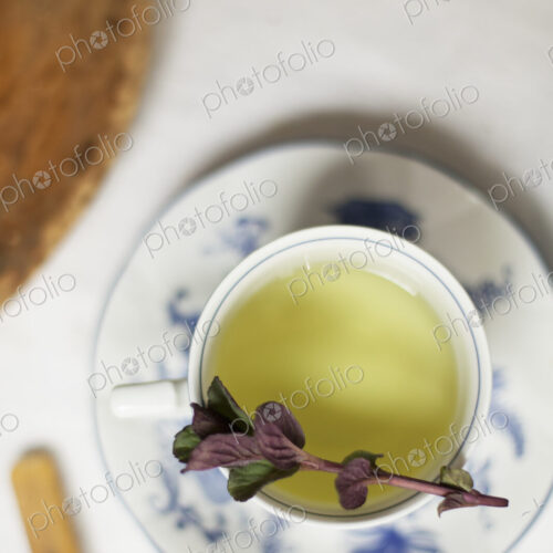 A cup of tea, clear coloured tea in a china cup, with a sprig of aromatic mint. A cup of tea, clear coloured tea in a china cup, with a sprig of aromatic mint.