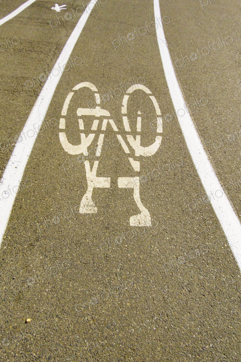 A cycle route in a public park, white painted outline of a bicycle, cycling lane on a…