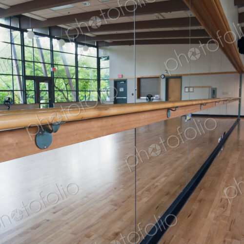A dance or ballet studio,with a sprung wooden floor. Barre and wall mirrors