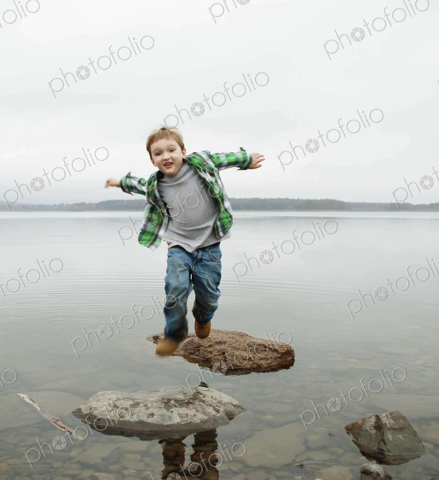 A day out at Ashokan lake. A boy jumping across stepping stones.