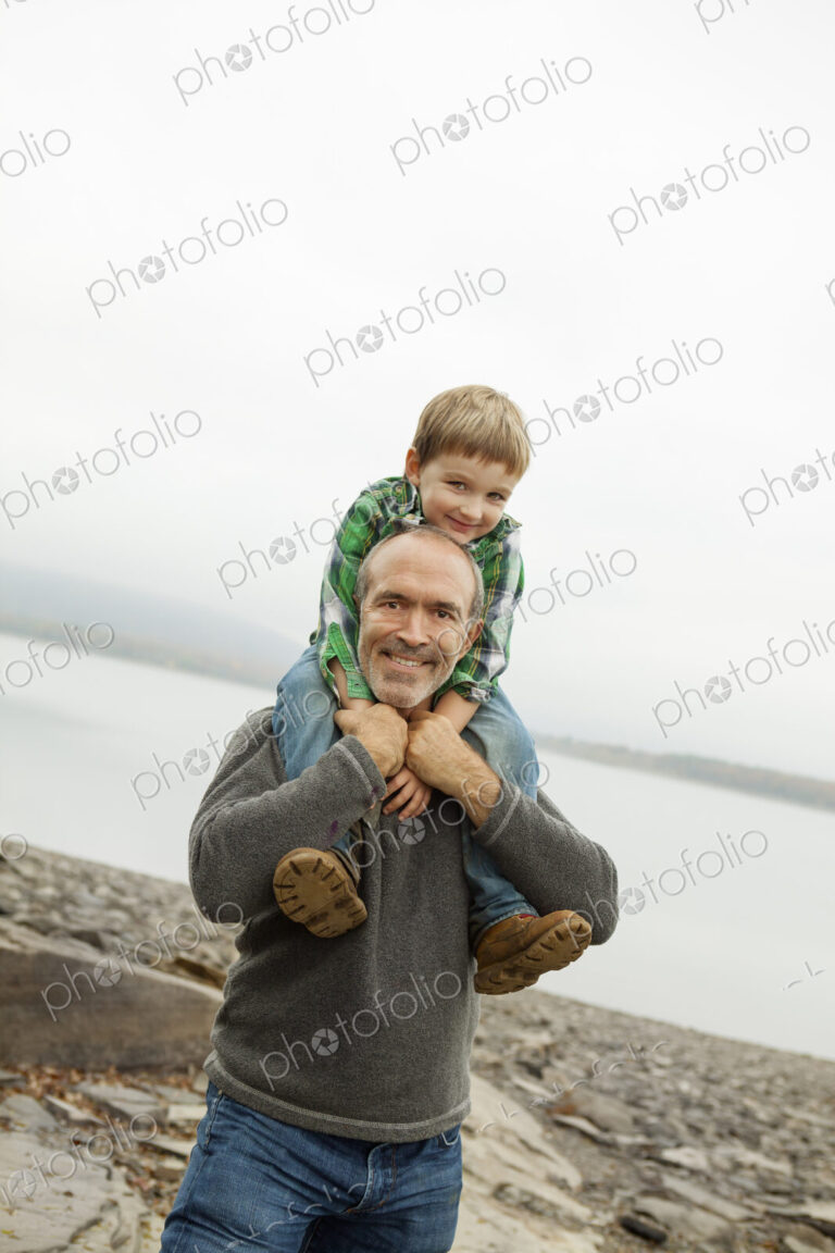 A day out at Ashokan lake. A man giving a child a shoulder ride.