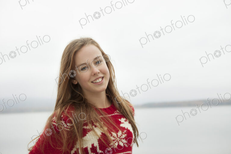 A day out at Ashokan lake. A young girl in a red winter knitted jumper.