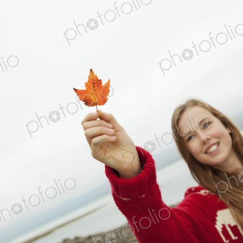A day out at Ashokan lake. A young girl in a red winter knitted jumper holding up a… A day out at Ashokan lake. A young girl in a red winter knitted jumper holding up a…