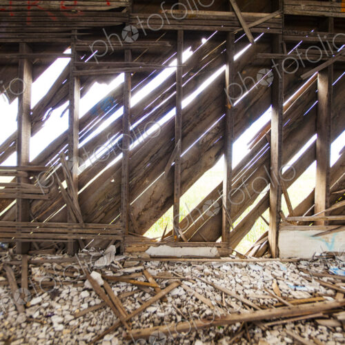 A derelict house, abandoned property, rotten broken beams and joists, sunlight coming…