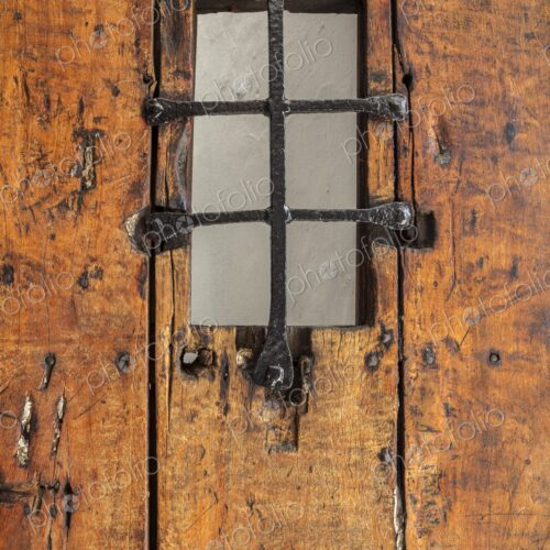 A detailed view of an old wooden door with an iron grate window at Castillo San Felipe… A detailed view of an old wooden door with an iron grate window at Castillo San Felipe…