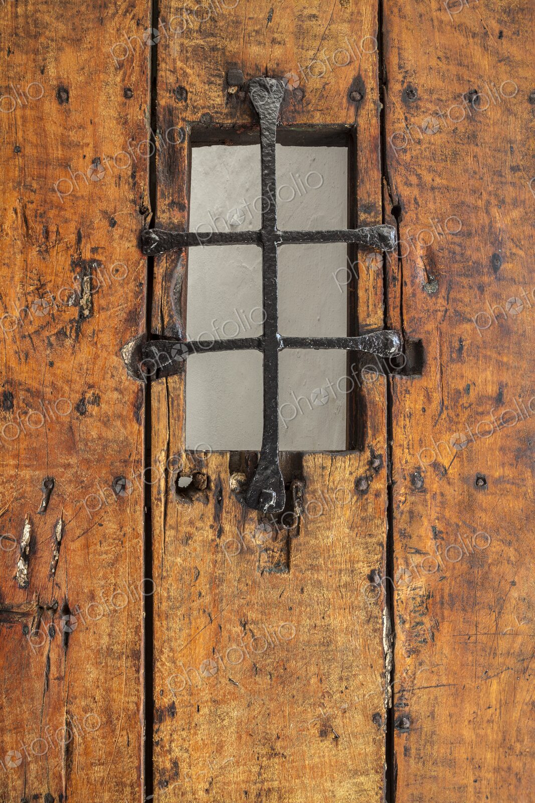 A detailed view of an old wooden door with an iron grate window at Castillo San Felipe…
