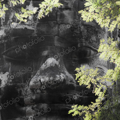 A diety head, a god's face in stone blocks, on the wall at Angkor Thom, part of the… A diety head, a god's face in stone blocks, on the wall at Angkor Thom, part of the…