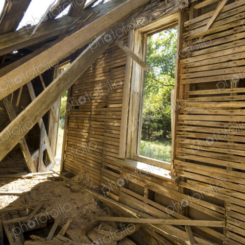 A dilapidated building, a ruin with timbers falling from the roof.