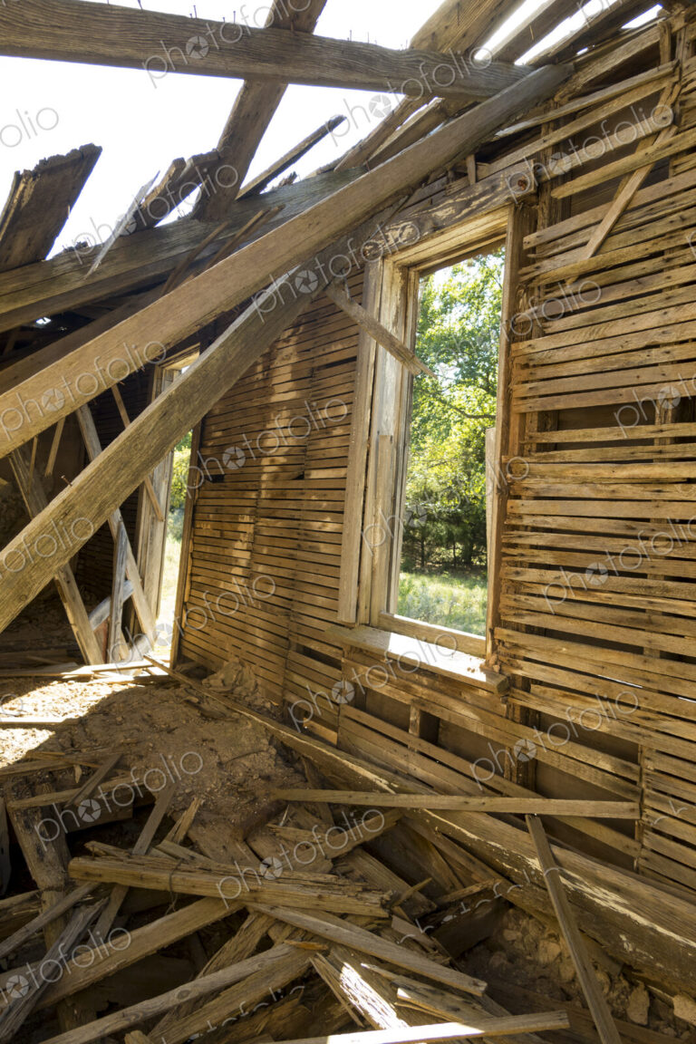 A dilapidated building, a ruin with timbers falling from the roof.