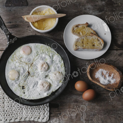 A dish of eggs, bread and sauce laid out on a table. A dish of eggs, bread and sauce laid out on a table.