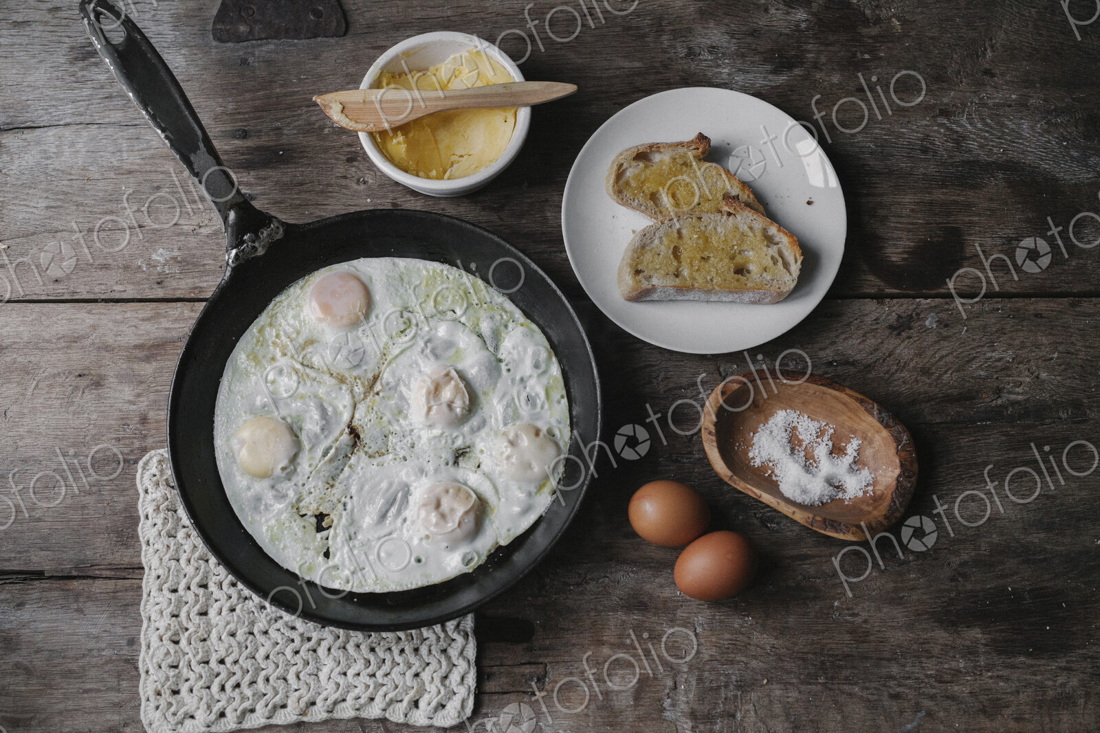 A dish of eggs, bread and sauce laid out on a table.