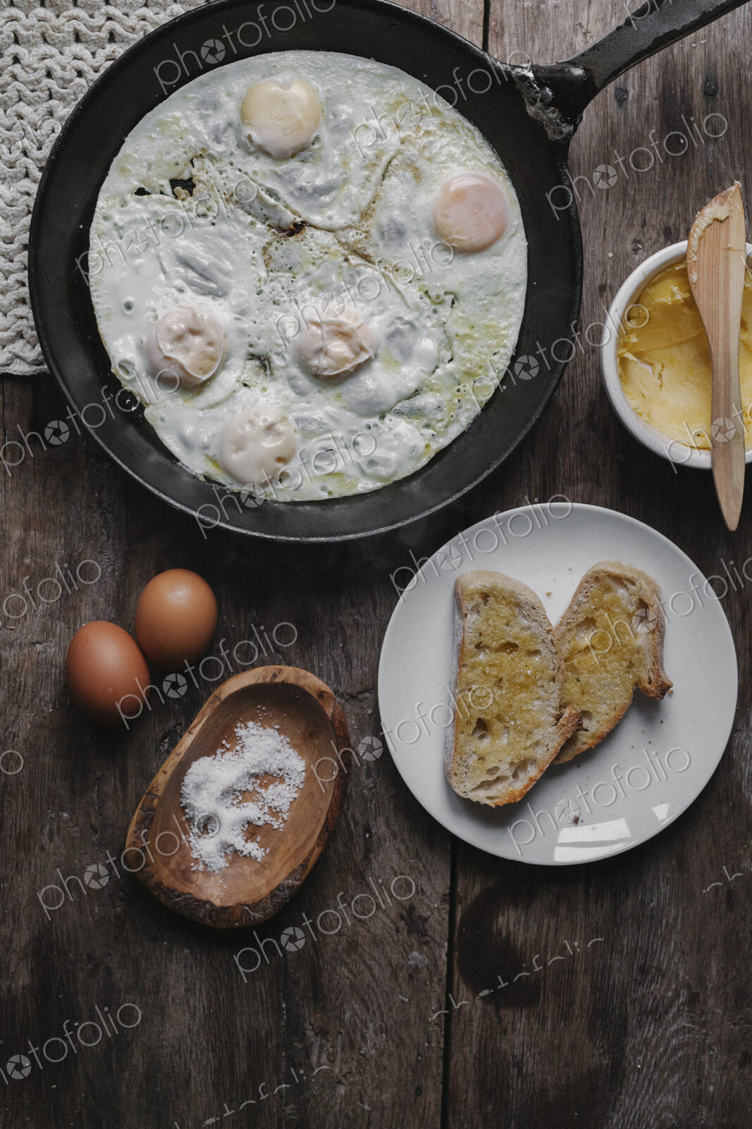 A dish of eggs, bread and sauce laid out on a table.