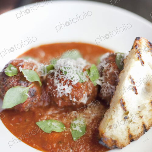 A dish of organic freshly prepared food. Grass-fed beef meatballs in tomato sauce with…