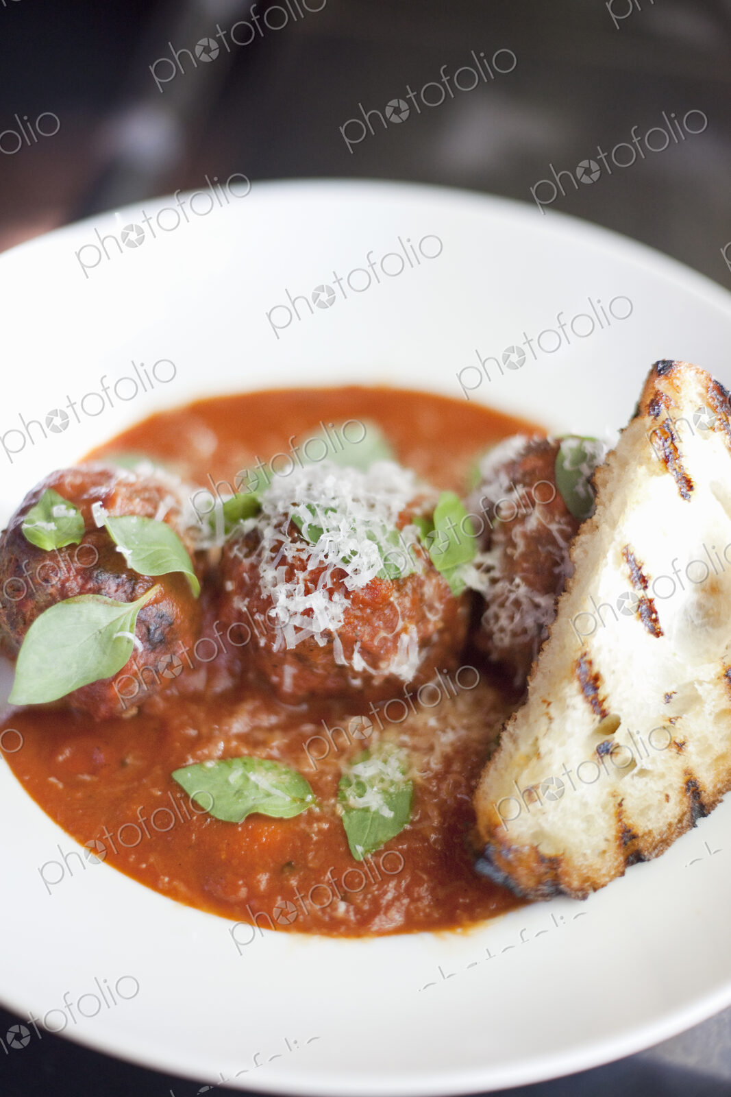 A dish of organic freshly prepared food. Grass-fed beef meatballs in tomato sauce with…