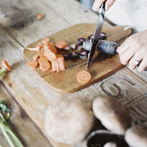 A domestic kitchen tabletop. A person chopping fresh vegetables on a chopping board… A domestic kitchen tabletop. A person chopping fresh vegetables on a chopping board…