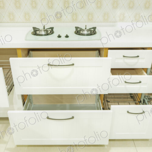 A domestic kitchen with fitted kitchen units, white doors and gas surface hob.