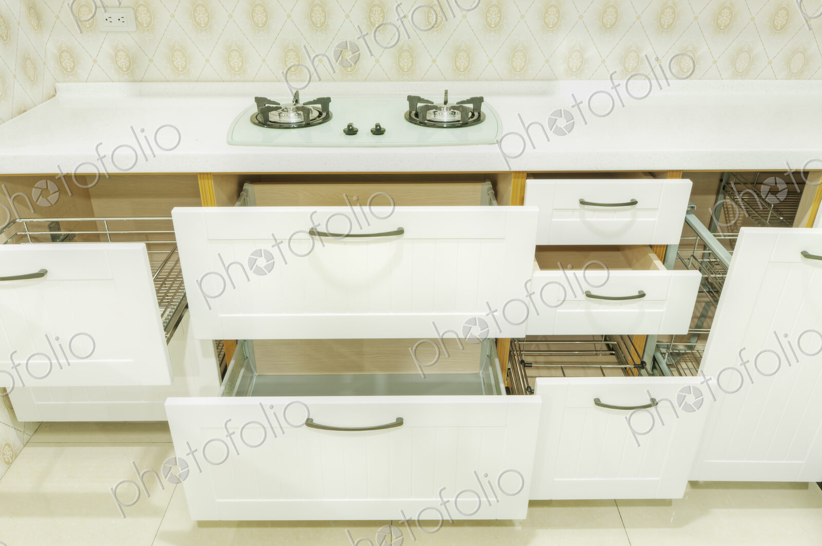 A domestic kitchen with fitted kitchen units, white doors and gas surface hob.