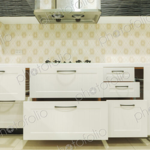 A domestic kitchen with fitted kitchen units, white doors and gas surface hob.