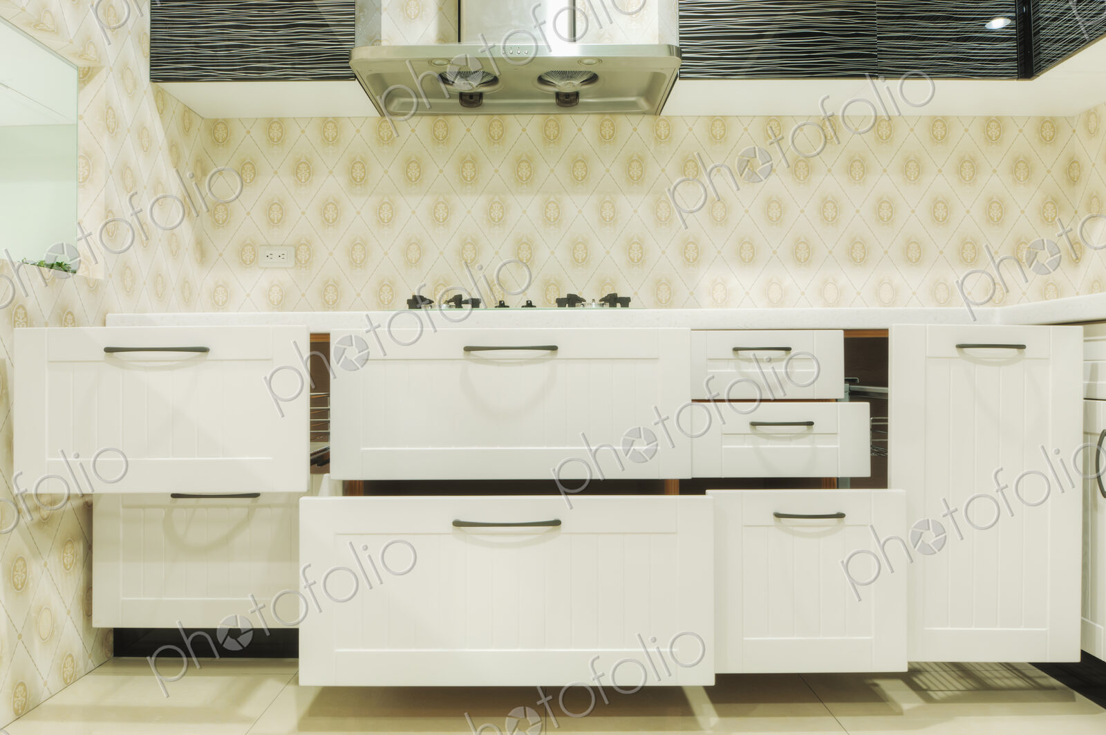 A domestic kitchen with fitted kitchen units, white doors and gas surface hob.
