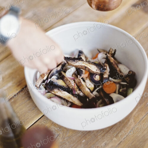 A domestic kitchen. A bowl of fresh chopped vegetables, in a white bowl. A person's… A domestic kitchen. A bowl of fresh chopped vegetables, in a white bowl. A person's…