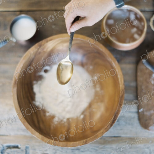 A domestic kitchen. A cook preparing a meal. A large bowl with oill and flour.…