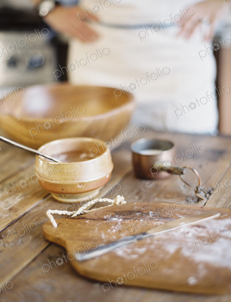A domestic kitchen. A cook preparing a meal. A large bowl with oill and flour.…