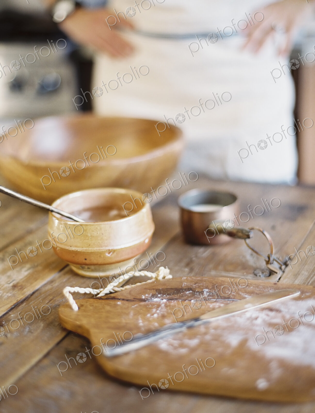 A domestic kitchen. A cook preparing a meal. A large bowl with oill and flour.…