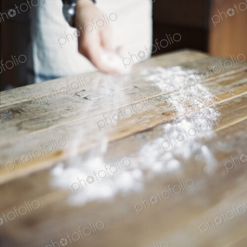 A domestic kitchen. A woman cooking. Spreading flour across a tabletop. A domestic kitchen. A woman cooking. Spreading flour across a tabletop.
