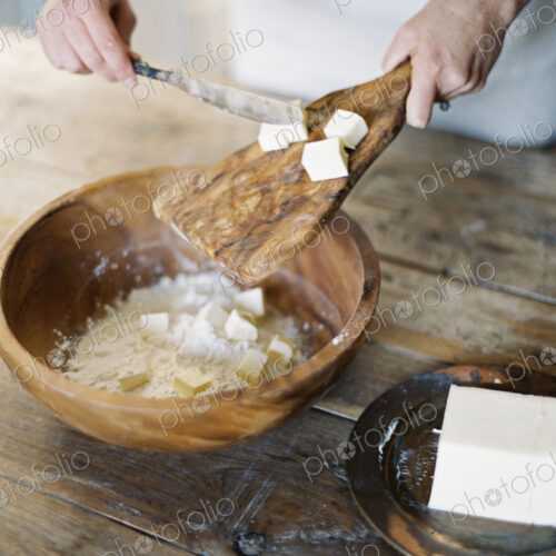 A domestic kitchen. A woman preparing a meal, mixing flour and fat to create pastry. A domestic kitchen. A woman preparing a meal, mixing flour and fat to create pastry.