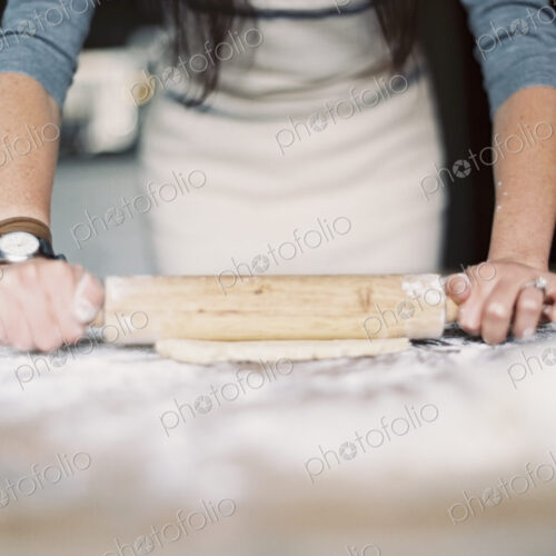 A domestic kitchen. A woman preparing a meal. Rolling out pastry on a table top. A domestic kitchen. A woman preparing a meal. Rolling out pastry on a table top.