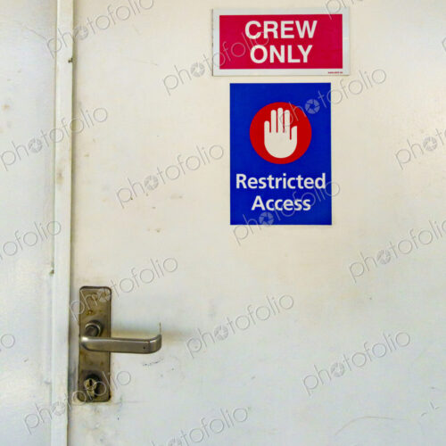 A door on a ferry with a sign Restriced Access, Crew Only. A door on a ferry with a sign Restriced Access, Crew Only.