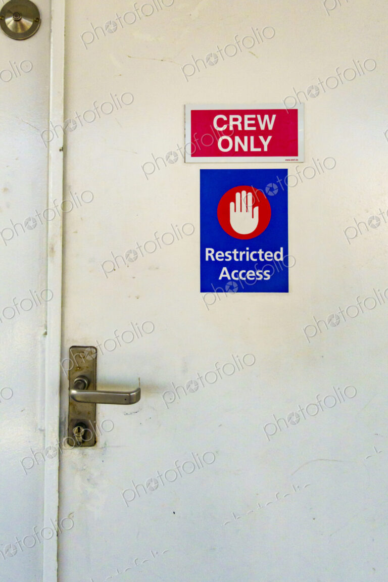 A door on a ferry with a sign Restriced Access, Crew Only.