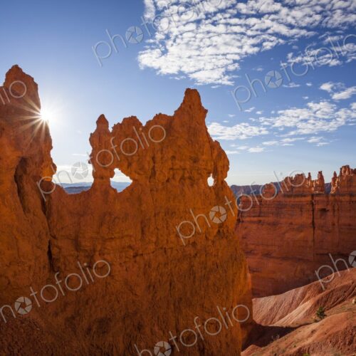 A dramatic hoodoo wall pierced with natural windows catches the sunburst at sunrise in… A dramatic hoodoo wall pierced with natural windows catches the sunburst at sunrise in…