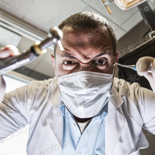 A dramatic view looking up from a patient's perspective of a scary looking dentist… A dramatic view looking up from a patient's perspective of a scary looking dentist…