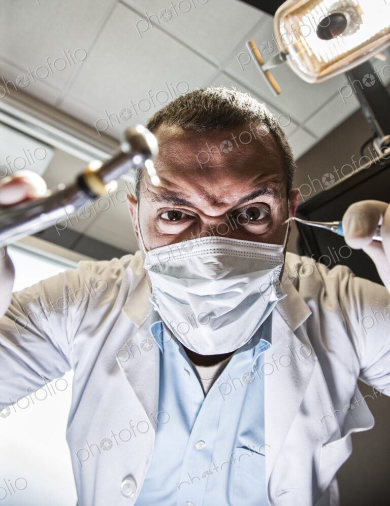 A dramatic view looking up from a patient's perspective of a scary looking dentist…