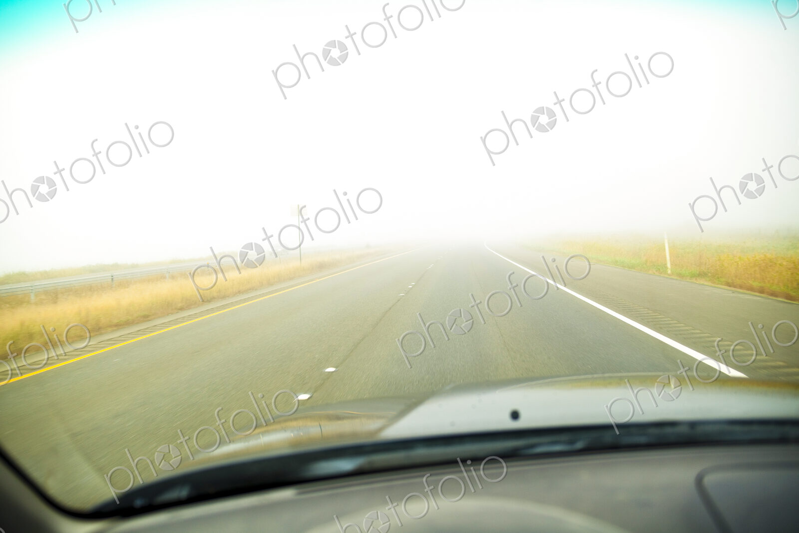 A driver’s view of the road ahead with thick fog across the road, limited visibility,.