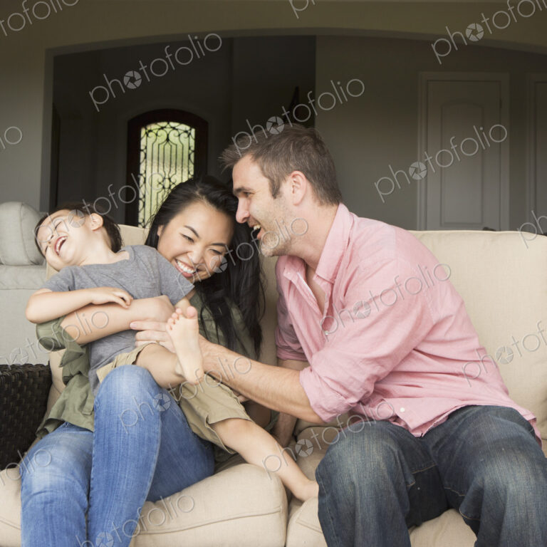 A family, a man and woman playing with their young son.