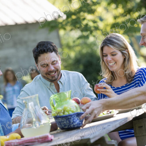 A family, adults and children seated around a table, enjoying a meal together.