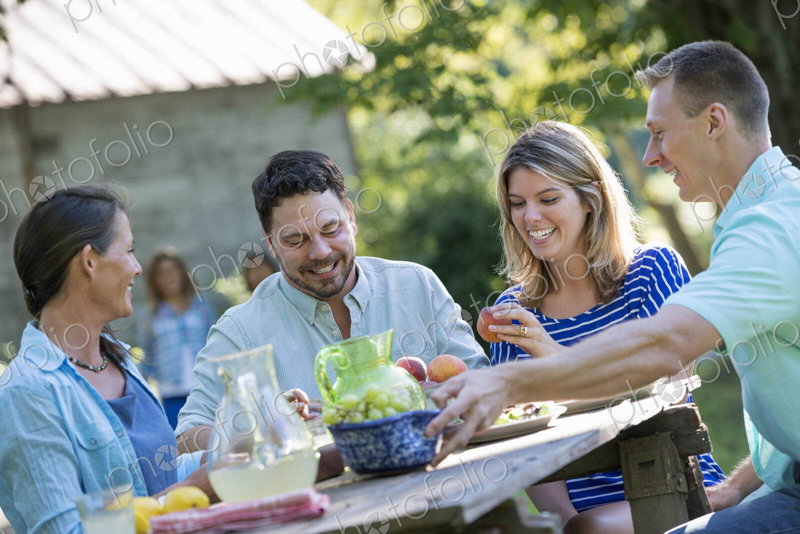 A family, adults and children seated around a table, enjoying a meal together.