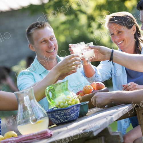 A family, adults and children seated around a table, enjoying a meal together.