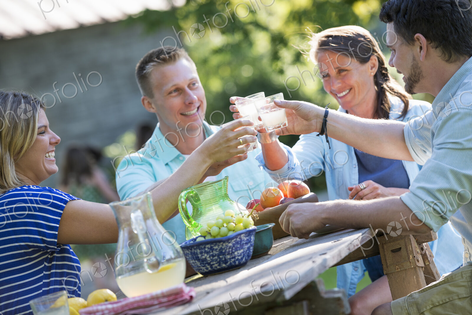 A family, adults and children seated around a table, enjoying a meal together.