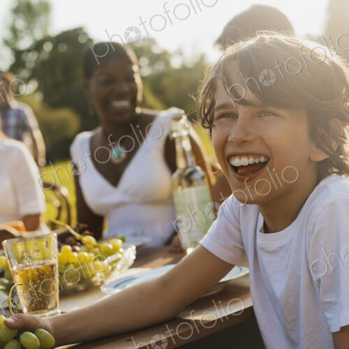 A family and friends having a meal outdoors. A picnic or buffet in the early evening. A family and friends having a meal outdoors. A picnic or buffet in the early evening.