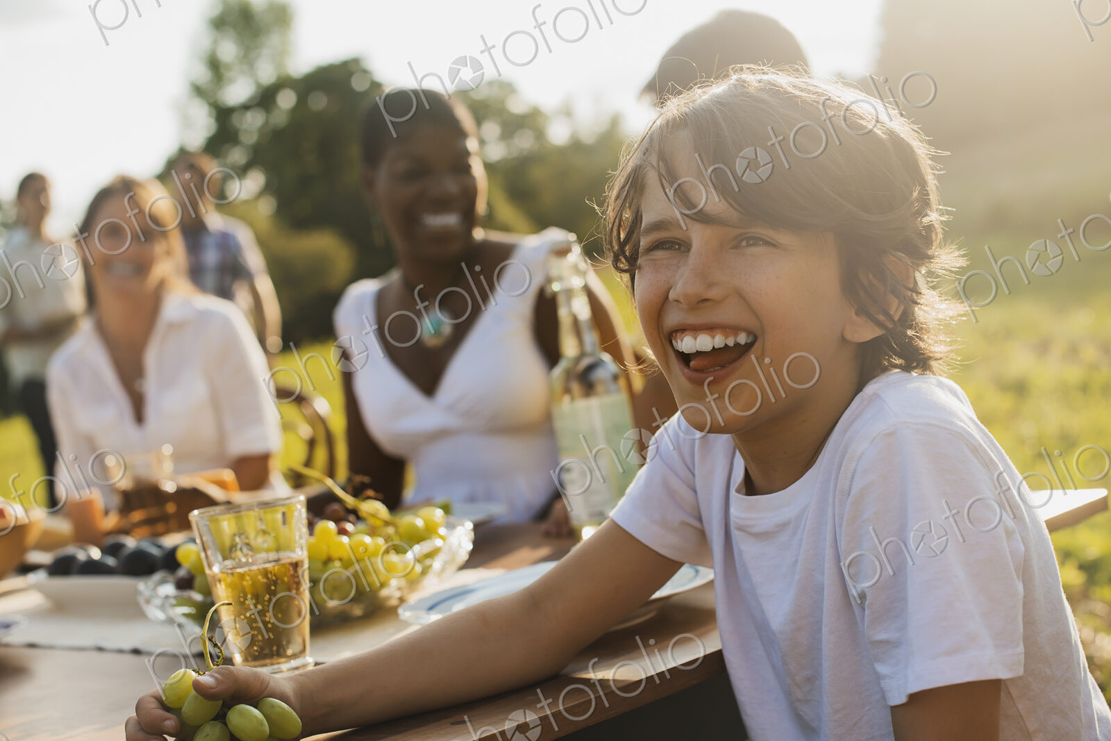 A family and friends having a meal outdoors. A picnic or buffet in the early evening.