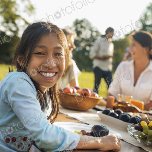 A family and friends having a meal outdoors. A picnic or buffet in the early evening. A family and friends having a meal outdoors. A picnic or buffet in the early evening.