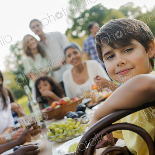 A family and friends having a meal outdoors. A picnic or buffet in the early evening. A family and friends having a meal outdoors. A picnic or buffet in the early evening.