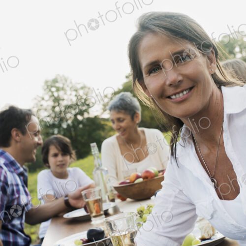 A family and friends having a meal outdoors. A picnic or buffet in the early evening. A family and friends having a meal outdoors. A picnic or buffet in the early evening.
