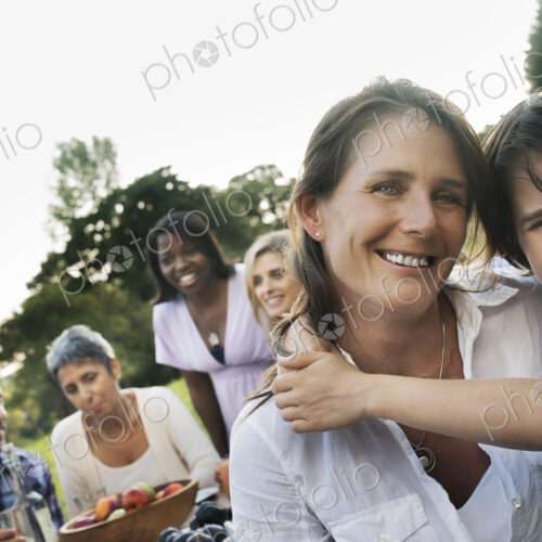 A family and friends having a meal outdoors. A picnic or buffet in the early evening. A family and friends having a meal outdoors. A picnic or buffet in the early evening.