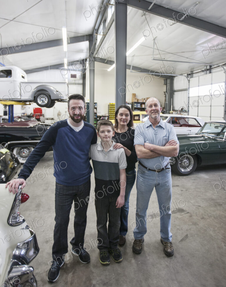 A family business, father, son and grandson, and a young woman posing in a classic car…