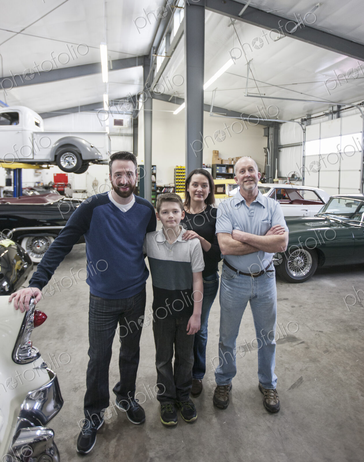 A family business, father, son and grandson, and a young woman posing in a classic car…